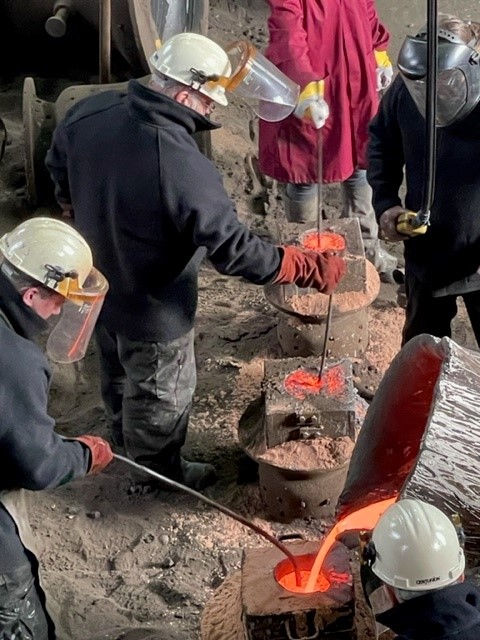 Sunken moulds being filled with molten metal. 